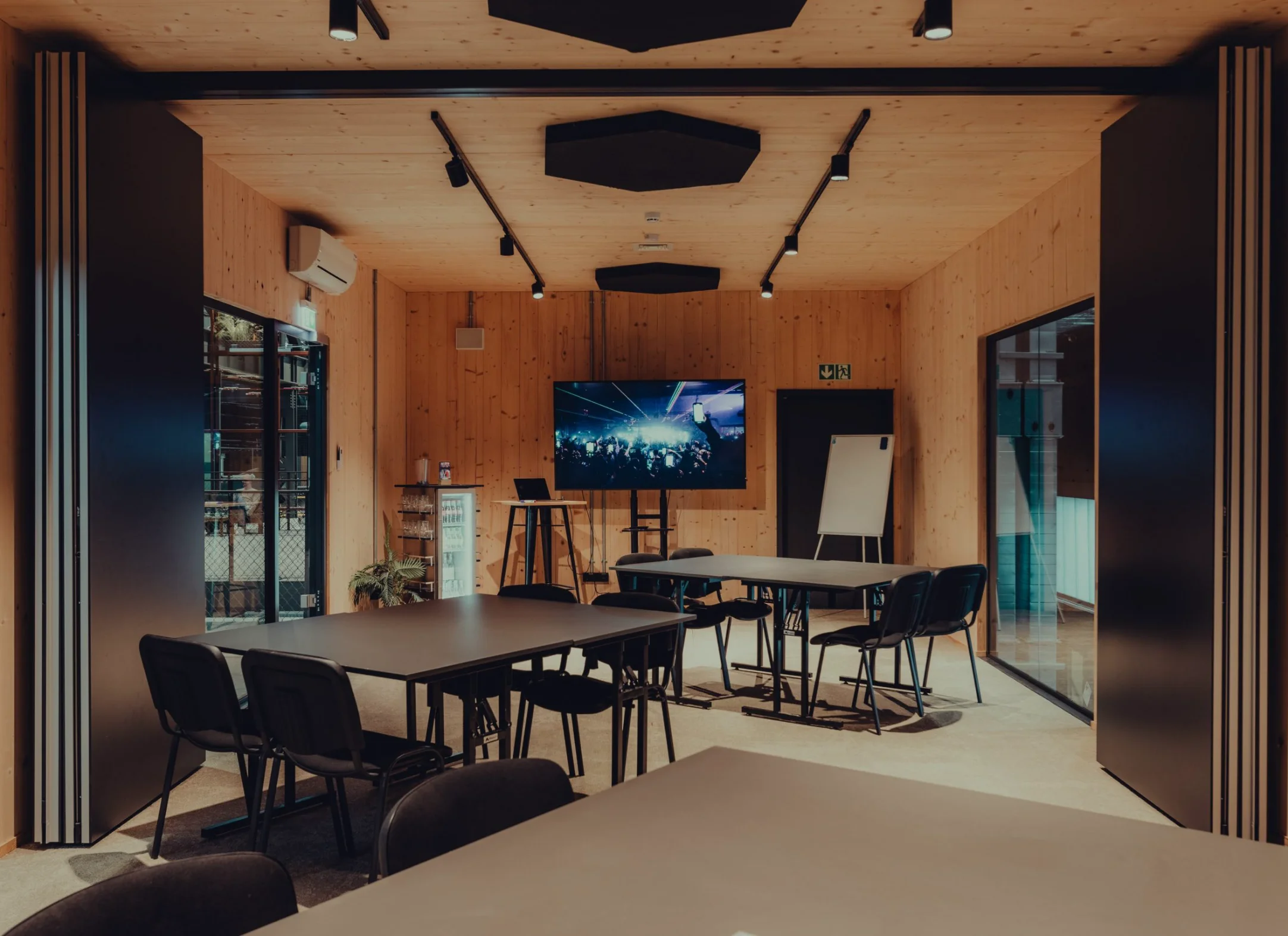 Großer Konferenzraum mit Tischen und Bildschirm